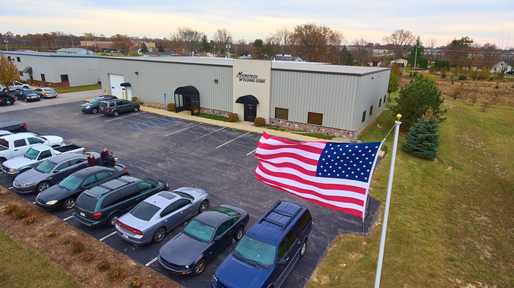 Outside the Fort Wayne Microtech facility with American Flag waving in the breeze