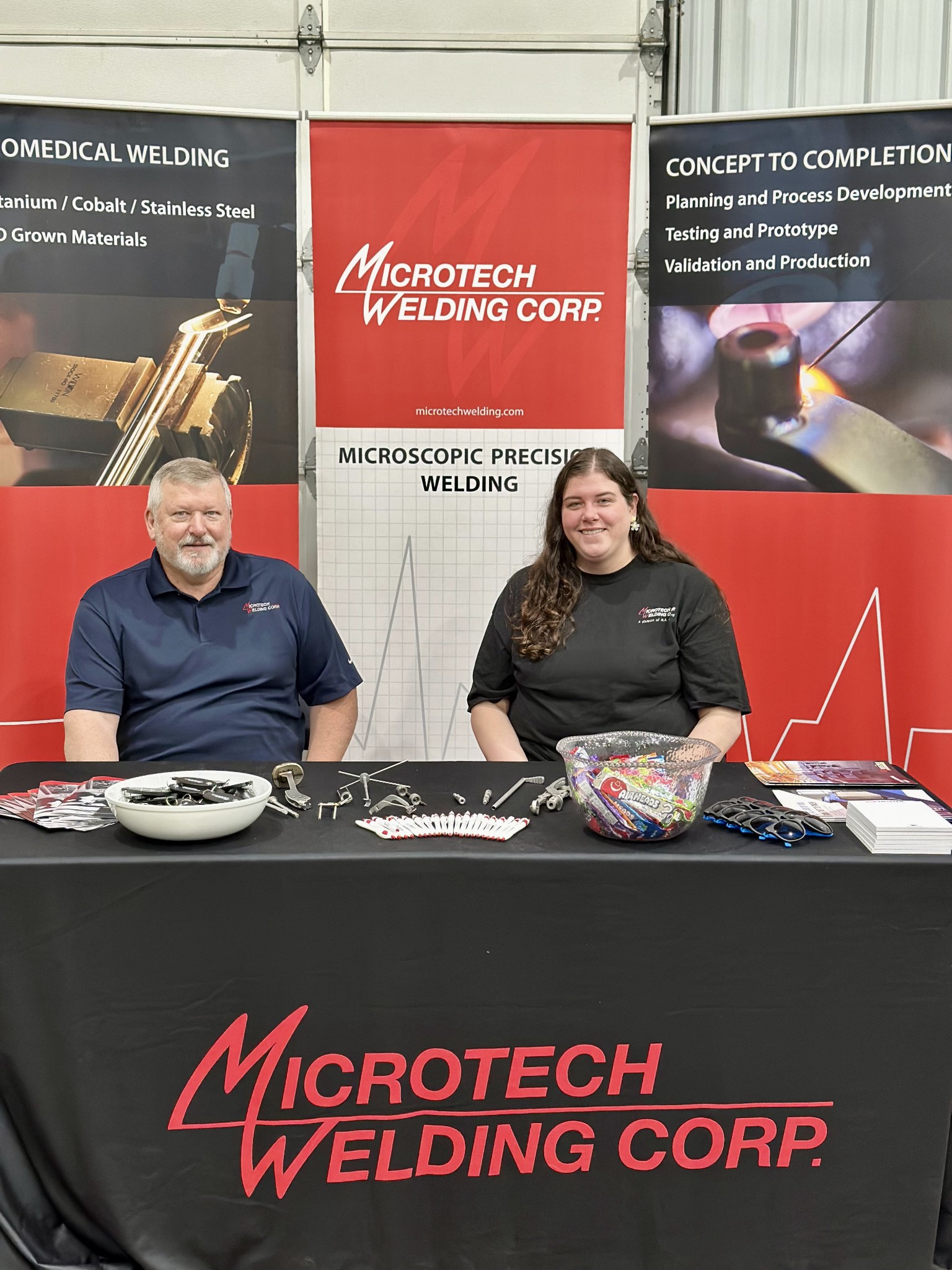 Two Microtech Employees sitting at a Microtech booth